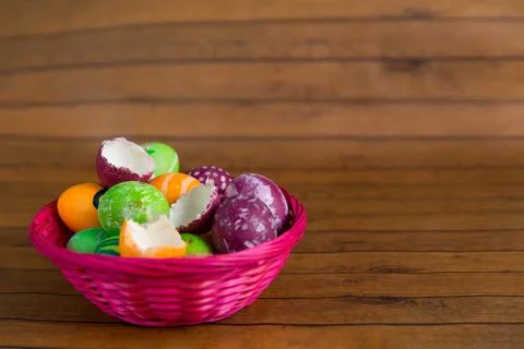 Easter colorful eggs and empty shells in basket on wooden background. April t Stock Photos