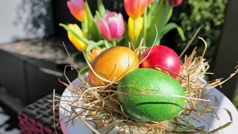 Easter colorful eggs rotate in nest with hey outdoor in sunny warming day. Stock Footage 234547849