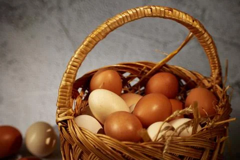 Easter composition. Basket with eggs, several eggs on a gray background Stock Photos