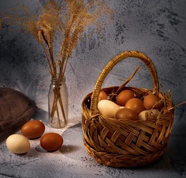 Easter composition. Basket with eggs, several eggs bouquet of dried flowers o Stock Photos
