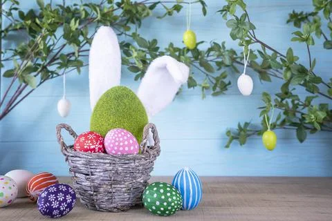 Easter composition with basket with hand painted easter eggs. Stock Photos