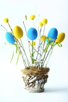 Easter composition of blue and yellow eggs with branches. Stock Photos