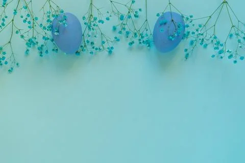 Easter composition of blue eggs and twigs of flowers on blue background Stock Photos