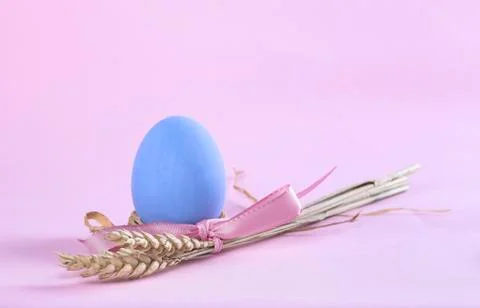 Easter composition with blue painted egg and sheaf of wheat Stock Photos