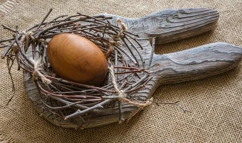 Easter composition - On the board with the ears of a rabbit lies a nest with an Stock Photos
