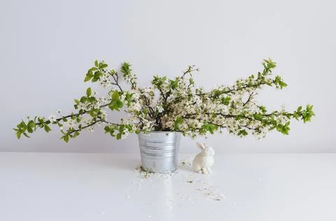 Easter composition with bouquet of cherry blossoms and rabbit on a white back Stock Photos