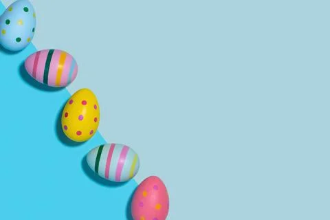 Easter composition of bright Easter eggs on a blue background. Stock Photos