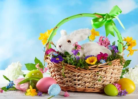 Easter composition with bunny in basket, spring flowers and colorful Easter.. Stock Photos