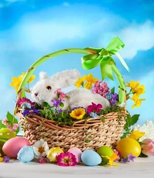 Easter composition with bunny in basket, spring flowers and colorful Easter.. Stockfoto's