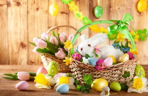 Easter composition with bunny in basket, spring flowers and colorful Easter.. Stock Photos