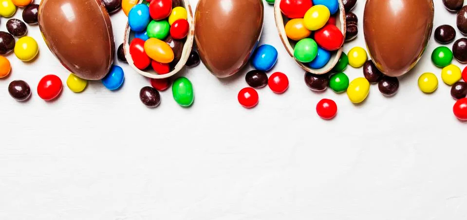 Easter composition with chocolate eggs and colorful candy, white background, Stock Photos