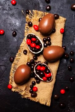 Easter composition with chocolate eggs and sweets, dark background, top view Stock Photos