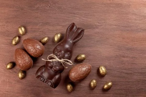 Easter composition with chocolate eggs and bunny on wooden background, space  Stock Photos