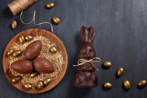 Easter composition with chocolate eggs and bunny on wooden background, space  Stock Photos
