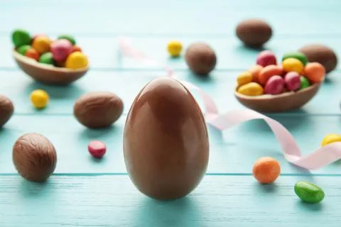Easter composition with chocolate eggs on blue background, space for text Stock Photos