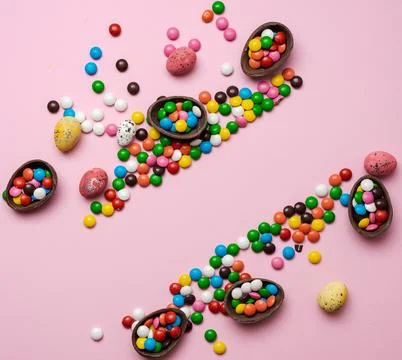 Easter composition with chocolate eggs on pink background. Stock Photos