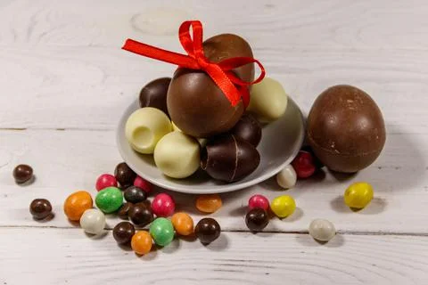 Easter composition with chocolate eggs on white wooden background Stock Photos