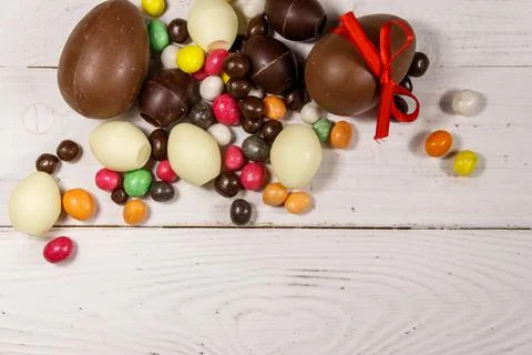 Easter composition with chocolate eggs on white wooden background Stock Photos