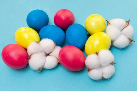 Easter composition. Colored eggs blue, yellow and red on a blue background. F Stock Photos