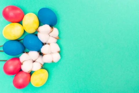 Easter composition. Colored eggs blue, yellow and red on a green background.  Stock Photos