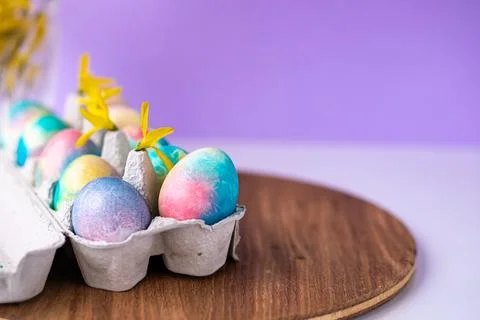 Easter composition with colorful eggs in a basket, spring yellow flowers on.. Stock Photos