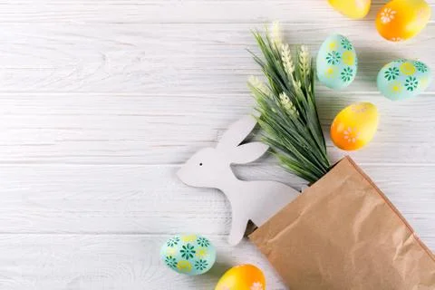 Easter composition with craft paper package, colorful easter eggs, bunny Foto stock