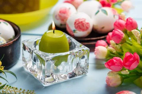 Easter composition with decorated eggs, flowers, burning candle and Easter Stock Photos