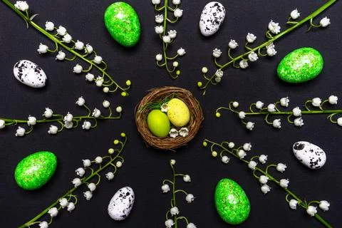 Easter composition. Decorative easter eggs in nest and beautiful white lilies Stock Photos