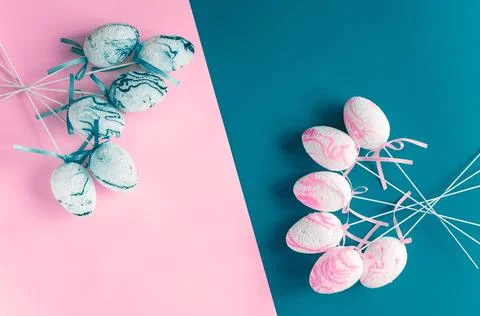 Easter composition. Decorative eggs are laid out on a two-tone pink and blue Stock Photos