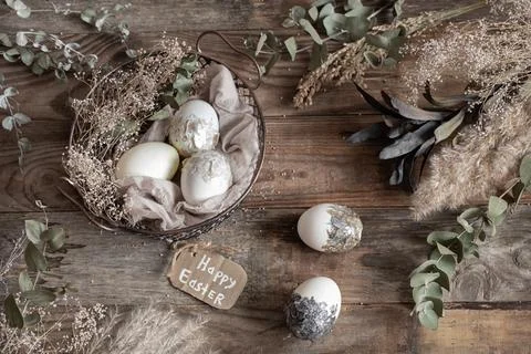 Easter composition with decorative eggs in a basket on a wooden surface top v Stock Photos