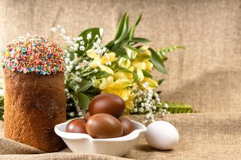 Easter composition of Easter cake, painted eggs and spring flowers on a backg Stock Photos