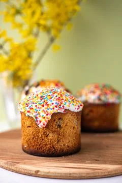 Easter composition with Easter cakes, wooden stand and spring flowers on a .. Stock Photos