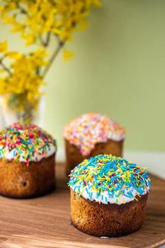 Easter composition with Easter cakes, wooden stand and spring flowers on a .. Stock Photos