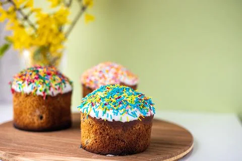 Easter composition with Easter cakes, wooden stand and spring flowers on a .. Stock Photos