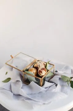 Easter composition. Easter eggs in a glass box on silk ribbons and on white a Stock Photos