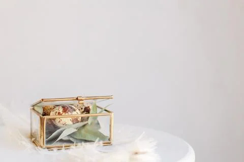 Easter composition. Easter eggs in a glass box on a white and gray background Stock Photos