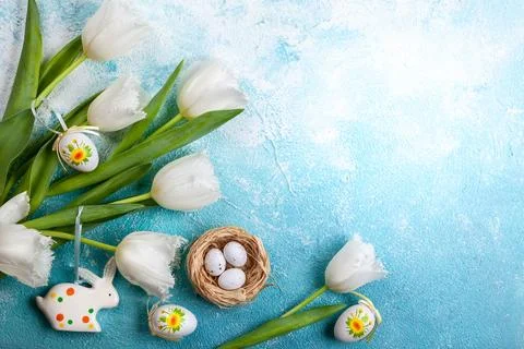 Easter composition with Easter eggs in nest and white tulips Stock Photos