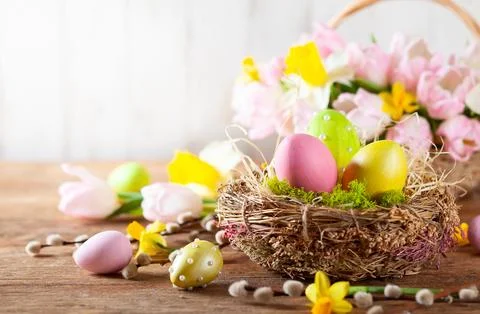 Easter composition with Easter eggs in nest, spring flowers and branches of.. Stockfoto's
