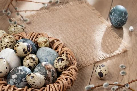 Easter composition - Easter eggs painted with natural dyes in a wicker nest o Stock Photos