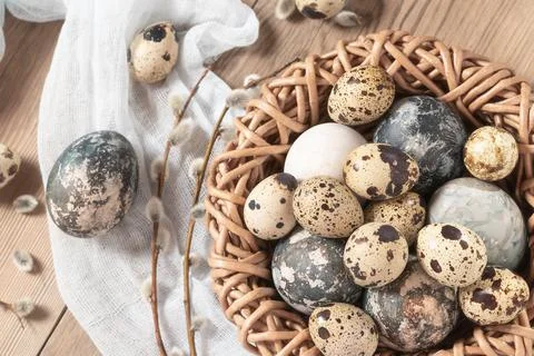 Easter composition - Easter eggs painted with natural dyes in a wicker nest o Stock Photos