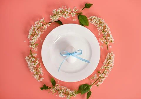 Easter composition. Easter eggs on a white plate, cherry branches in the shape Stock Photos