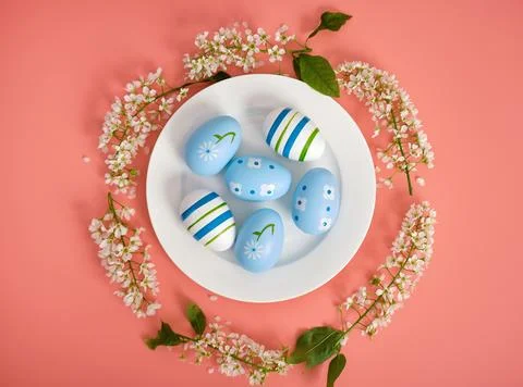 Easter composition. Easter eggs on a white plate, cherry branches in the shape Stock Photos