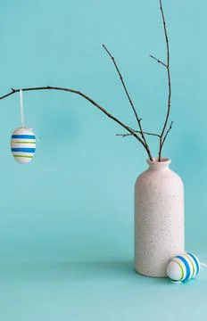 Easter composition with egg hanging on dry branch placed in vase 库存照片