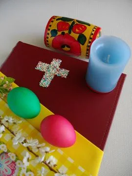 Easter composition with eggs and candles on the Bible. Stock Photos