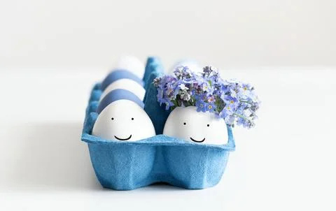 Easter composition with eggs in a blue cardboard box on white background.  Stock Photos
