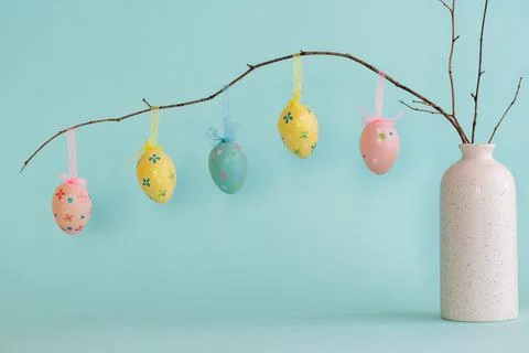 Easter composition with eggs hanging on dry branch placed in vase Stock Photos