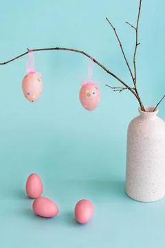 Easter composition with eggs hanging on dry branch placed in vase Stock Photos
