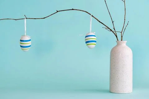 Easter composition with eggs hanging on dry branch placed in vase Stock Photos