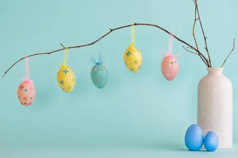 Easter composition with eggs hanging on dry branch placed in vase Stock Photos