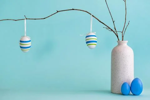 Easter composition with eggs hanging on dry branch placed in vase Stock Photos